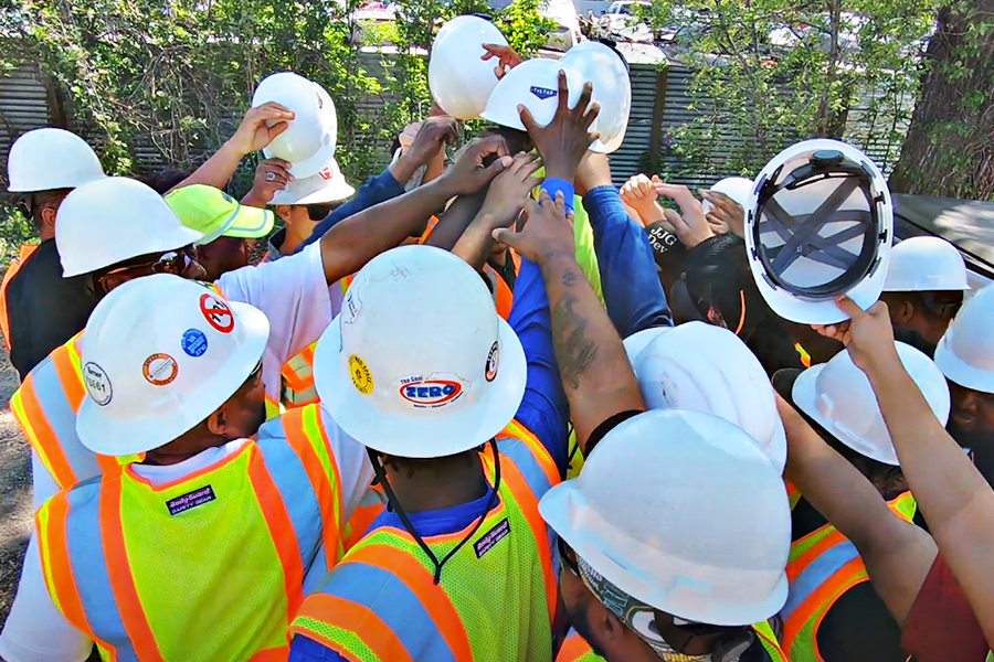 Trabajadores de la construcción juntando las manos