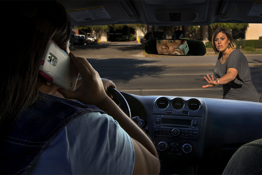 Conductor distraído en el teléfono celular acercándose a una mujer en el cruce de peatones