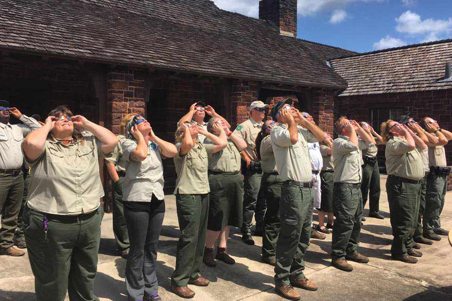 Park rangers viewing eclipse with viewing glasses
